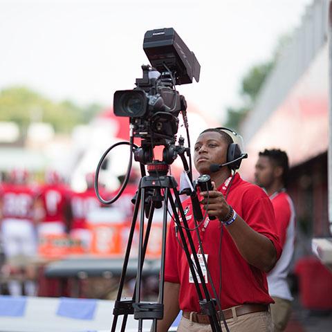 Student behind camera at sporting event